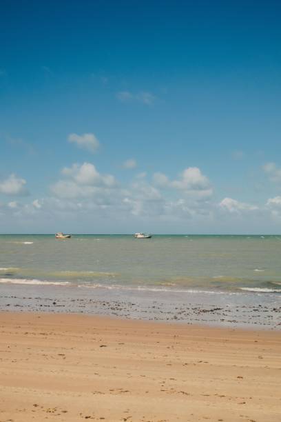 istock Serene beach scene with boats and blue sky. 2186957820