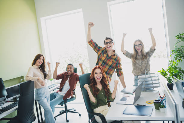 istock Photo of group five young corporate workers use computer speak phone drink coffee workstation office business center indoors 2186959530