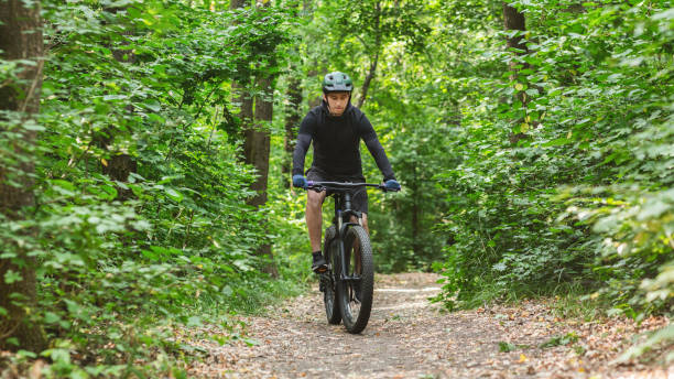 istock Biker in helmet riding bicycle by forest trail 2186959786