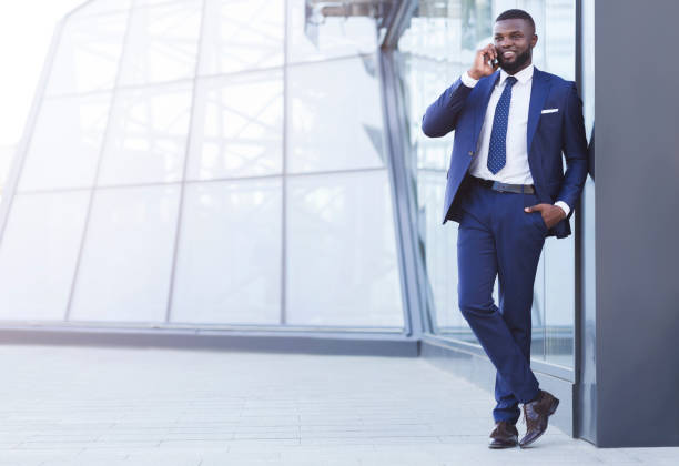 istock Smiling Entrepreneur In Suit Having Phone Conversation Standing In City 2186963745