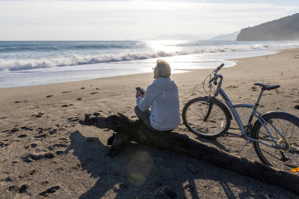 istock Mature man pauses by water's edge with bicycle 2186965054