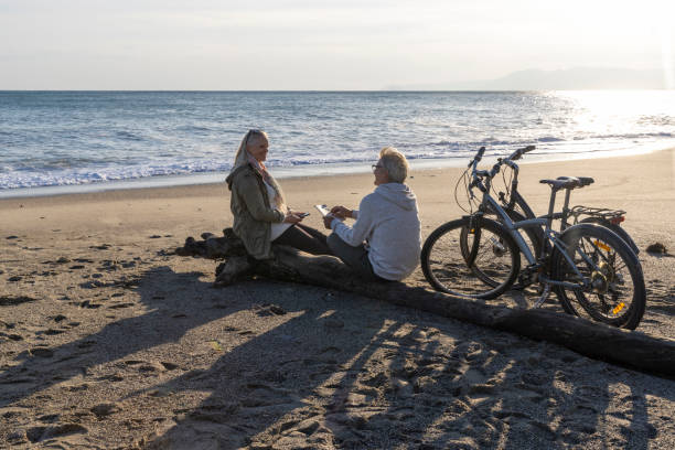 istock Mature couple talk by water's edge with bicycles 2186965220