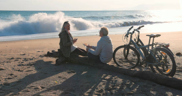 istock Mature couple talk by water's edge with bicycles 2186965349