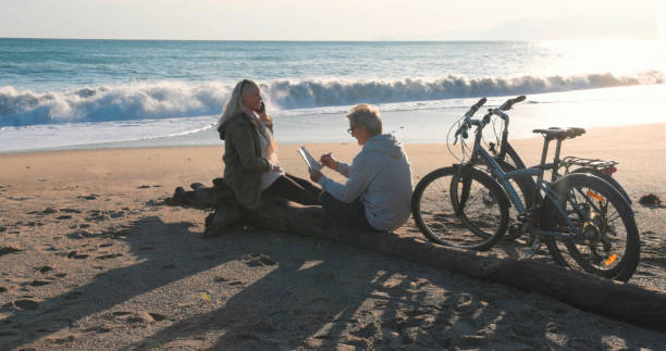 istock Mature couple talk by water's edge with bicycles 2186965367
