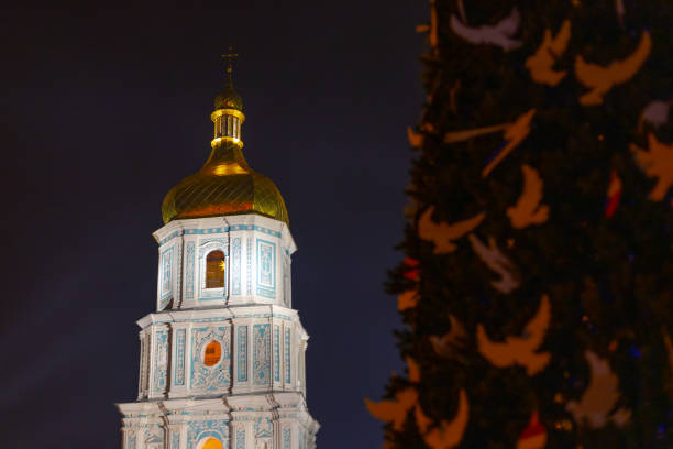 Kyiv, Ukraine  - December 24, 2022: Christmas tree on Sofiyivska Square in Kyiv isdecorated with white pigeons and flags of countries that help Kyiv to cope with the war-related challenges and consequences