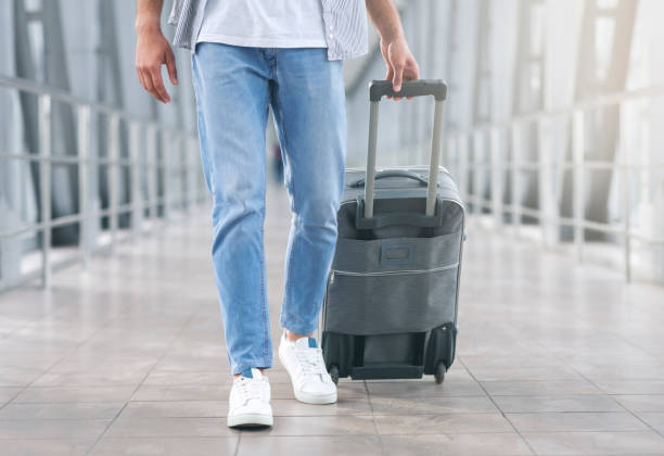 istock Man walking with luggage at airport corridor 2186968951