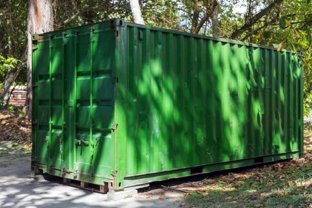 istock Green cargo container stands in shadow of trees on a summer day 2186969152