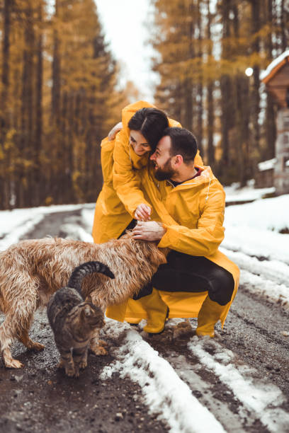 istock Joyful Couple Bonding With Their Pets Hugging in Middle of Forest Path 2186970995