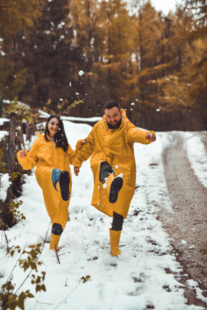 istock Goofy Couple Laughing While Kicking Snow on Morning Forest Walk 2186972030