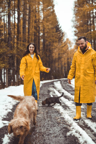 istock Lovely Couple Watching Their Dog Running And Enjoying Time Exploring Forest 2186972821