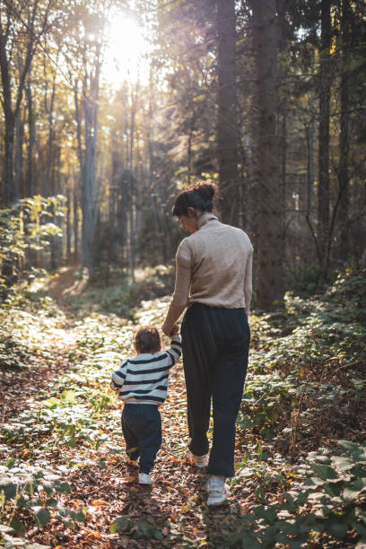 istock Mother and child walking through a peaceful forest path 2186975314