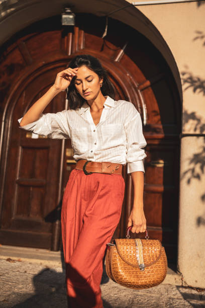 istock Stylish woman walking confidently in sunny urban setting 2186975447