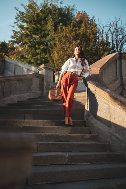istock Confident woman walking down stone stairs in sunlight 2186975454