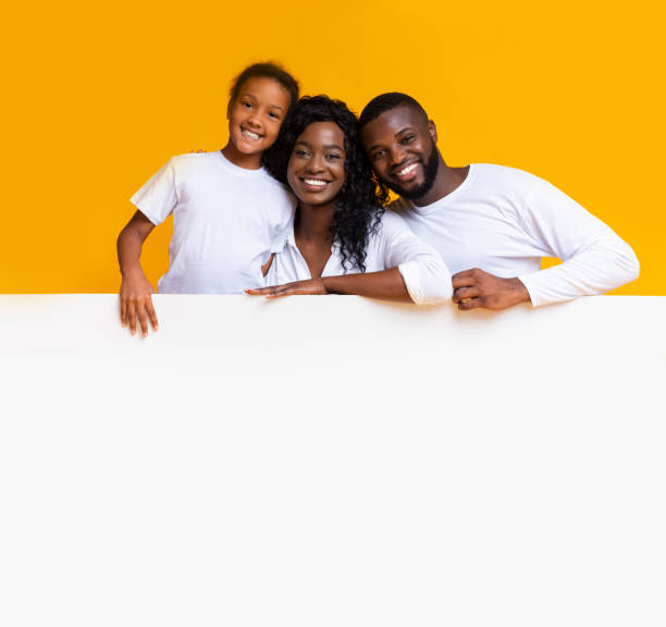 istock Happy afro family leaning on blank white board for advertisement 2186978010