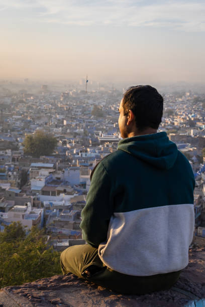 istock young man looking crowded city view from mountain top at morning 2186978600
