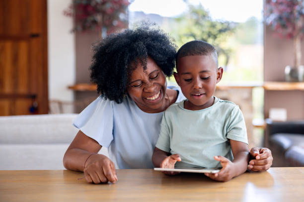 istock Grandmother babysitting her grandson and supervising him while using a digital tablet 2186978785
