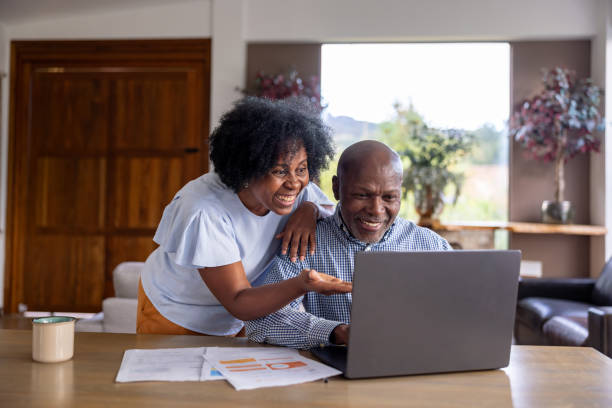 istock Happy senior couple paying bills from home using their laptop 2186978804