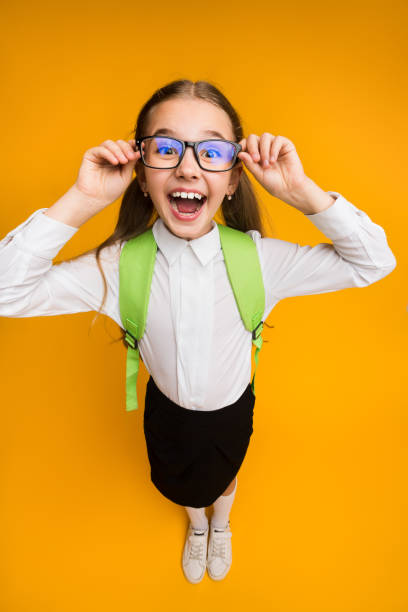 istock Excited Elementary School Girl In Eyewear Posing On Yellow Background 2186979024