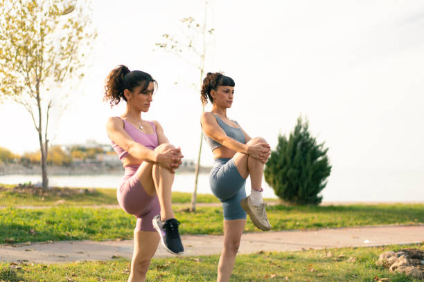istock Two young women warming up before exercising in the park 2186979364