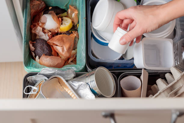 istock The woman throws plastic can can to the one of four container for sorting garbage. Garbage can with separate compartments for sorting recyclables 2186979941