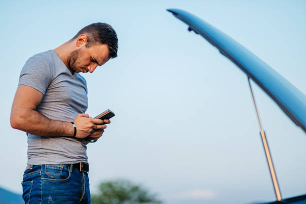 istock Mid-Adult Man Calling Road Assistance While Having Car Problems On The Street 2186981888