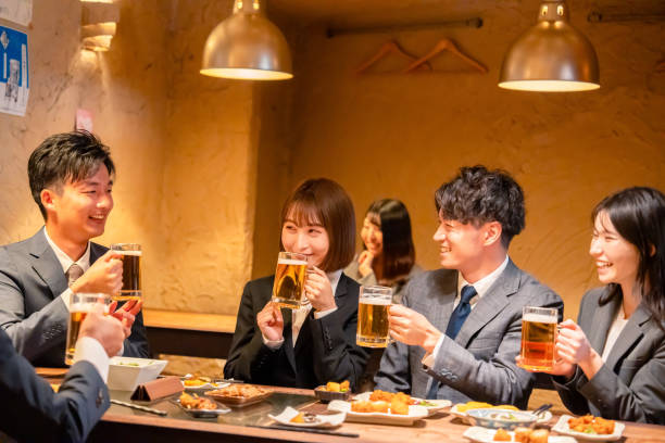 居酒屋で盛大な乾杯をするビジネスマン - お酒 ストックフォトと画像