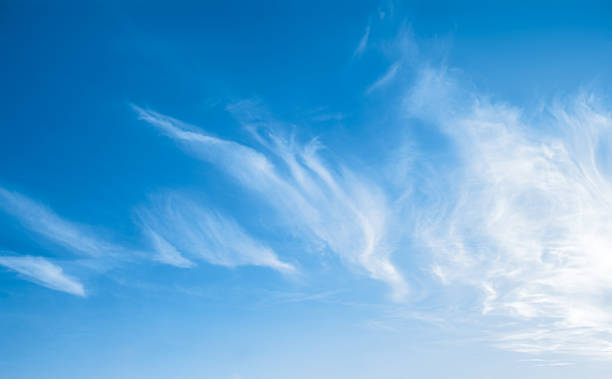 Beautiful cirrus clouds in the dark blue sky. Clear midday scene in the air at amazing weather. Bright sunlight with soft clouds