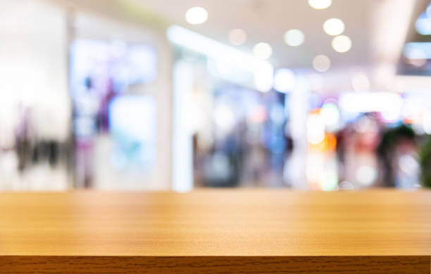 Wooden board empty table and blurred shopping mall in the background