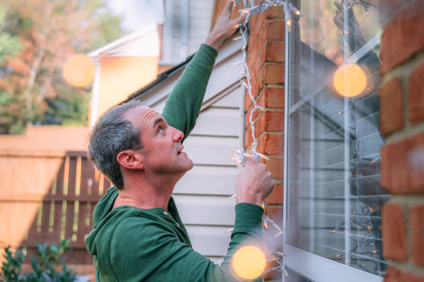 istock Man Hanging Christmas Lights on a Window, Decorating for Christmas Holiday 2186987264