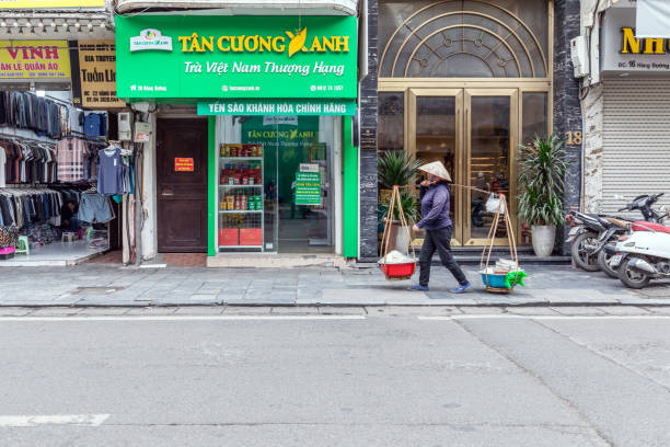 Hanoi, Vietnam - March 20, 2024: A street vendor sells food in a traditional Vietnamese way on the street in downtown Hanoi