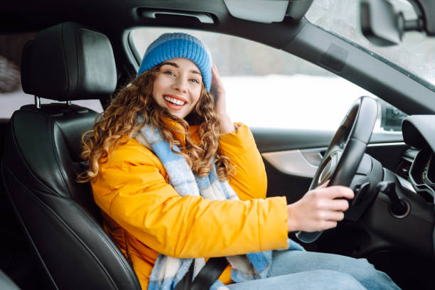 istock Young woman driving car on winter highway during day time. 2186990104