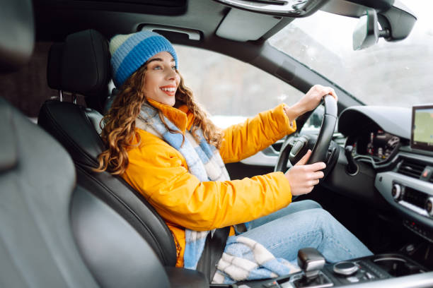 istock Young woman driving car on winter highway during day time. 2186990107