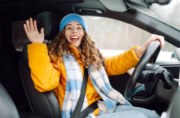istock Young woman driving car on winter highway during day time. 2186990141