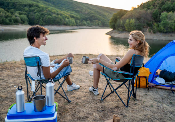 istock Friends relax and have fun while camping by the lakeside 2186992388