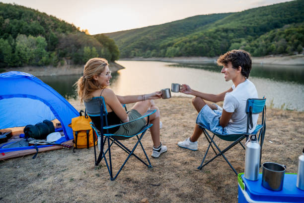 istock Friends relax and have fun while camping by the lakeside 2186992397