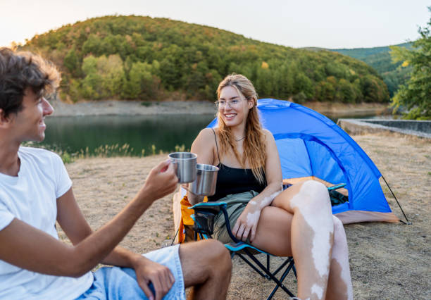 istock Friends relax and have fun while camping by the lakeside 2186992515