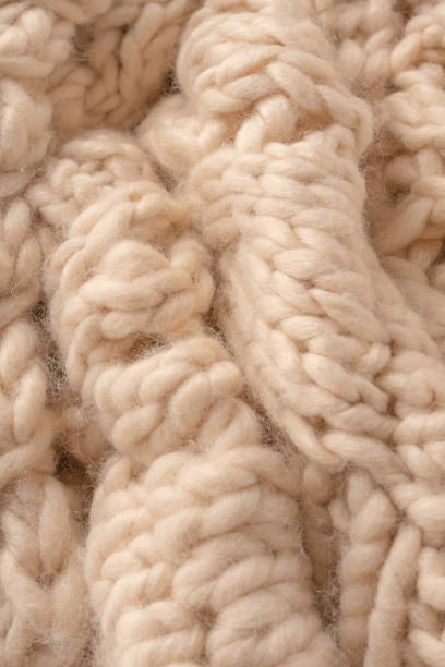 istock A fragment of beige knitted fabric, knitted from white sheep wool. 2186992569