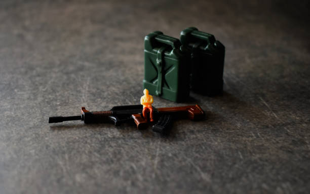 Small figure taking photos in front of plastic bucket and spade