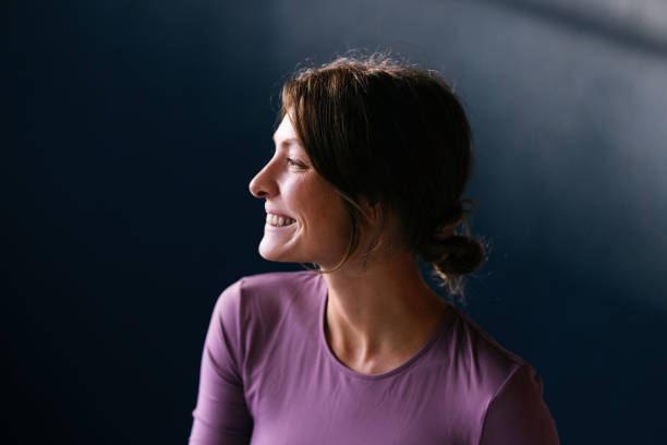 istock Woman Smiling in Natural Lighting with a Dark Background 2186993513