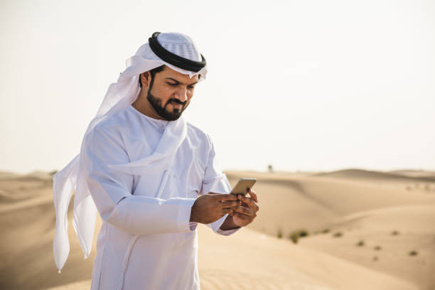 istock sheik on the phone in the desert 2186996327