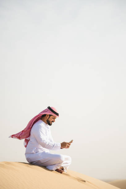 sheik on the phone in the desert