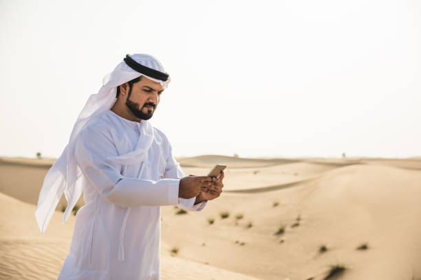 istock sheik on the phone in the desert 2186996581