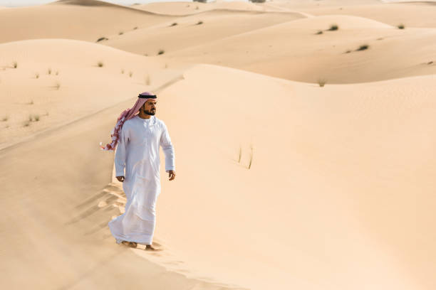 istock arabic man walking in the desert 2186997216