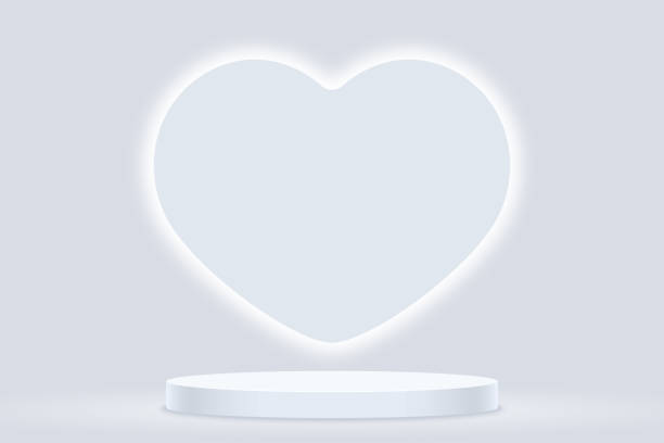 istock Light grey podium for product presentation with big white heart illuminated 2186997328
