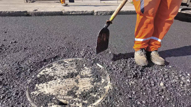 istock Construction workers working on a new asphalt layer on a public street. 2186997920