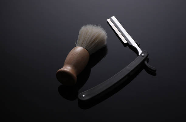 istock Shaving brush with a straight razor on a black background with reflection 2187000297