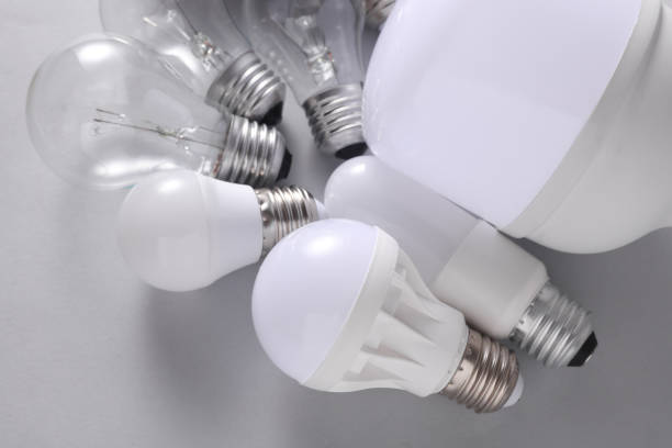 istock LED and ncandescent light bulbs on gray background. 2187001934