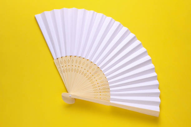 istock Traditional white Asian hand fan on yellow background. 2187001995