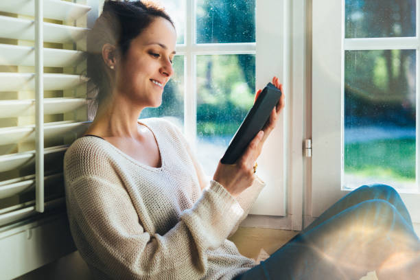 istock Woman at home reading a e-book 2187011783