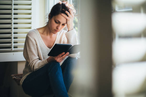 istock Woman at home reading a e-book 2187011845